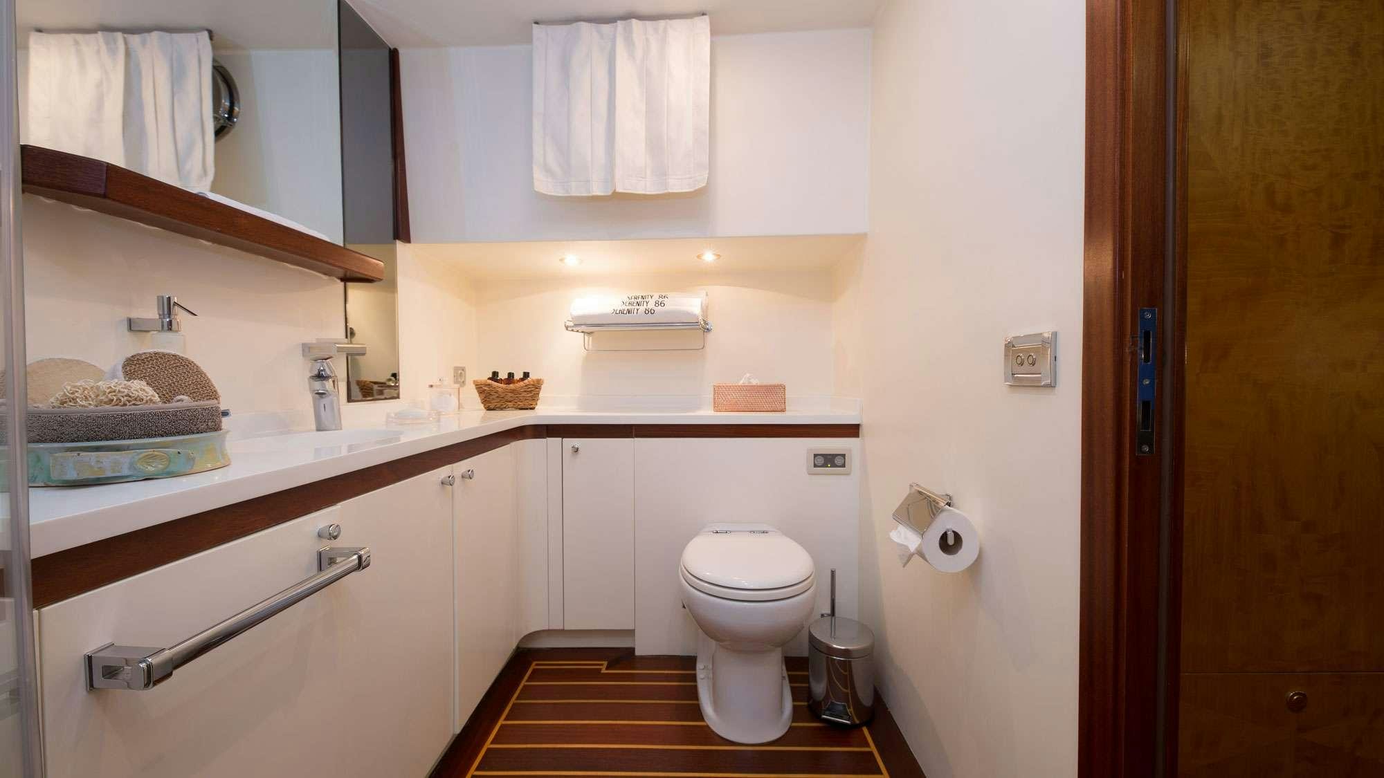 a bathroom with a toilet and a sink aboard SERENITY 86 Yacht for Charter