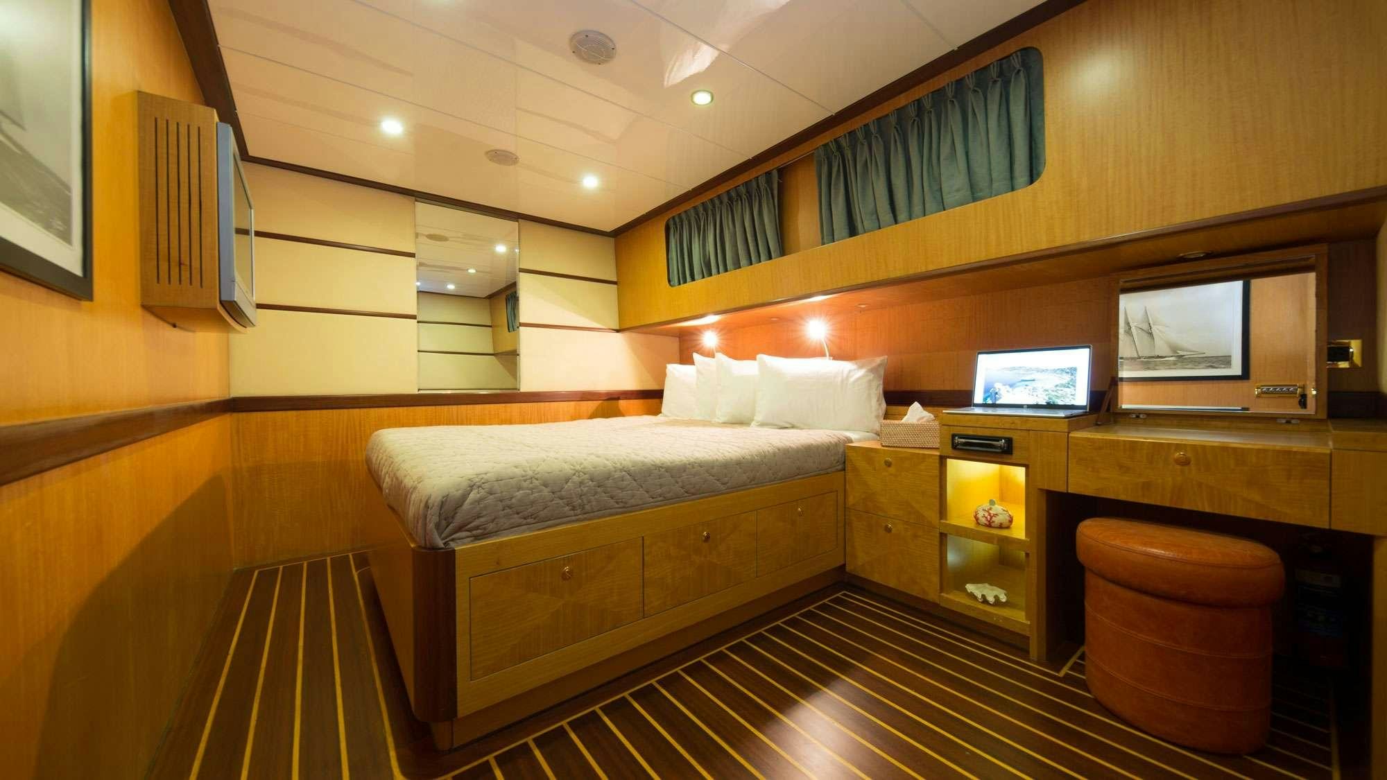 a room with a bed and a tv aboard SERENITY 86 Yacht for Charter