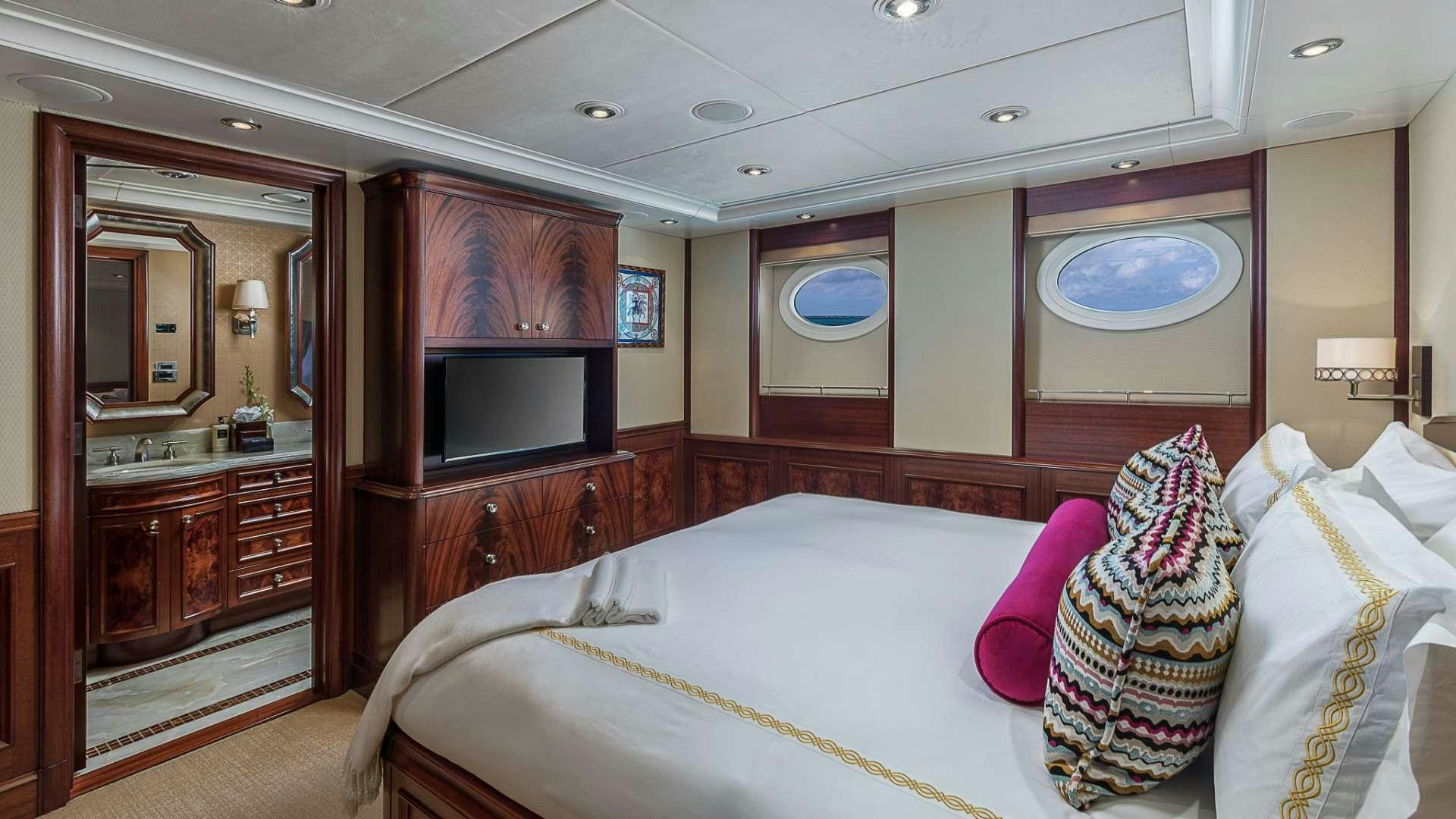 a bedroom with a bed and a television aboard AVALON Yacht for Charter