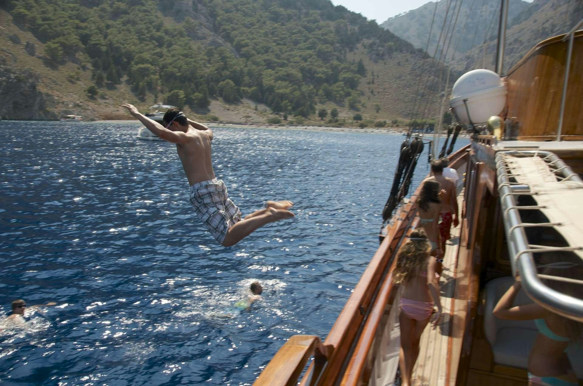 a person jumping off a boat aboard MATINA Yacht for Charter