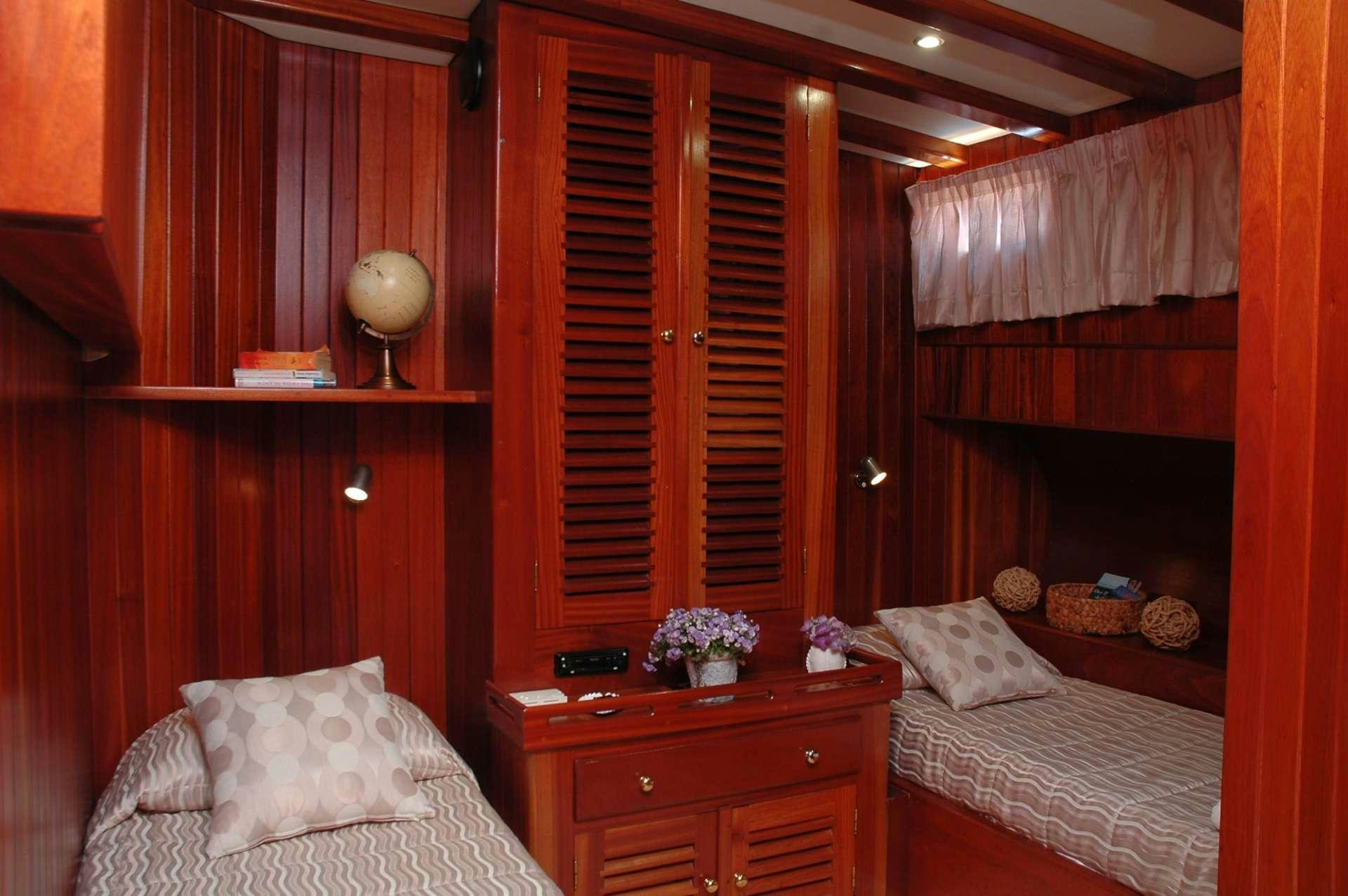 a room with a bed and a dresser aboard MATINA Yacht for Charter