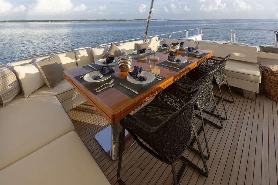 a table set for a meal on a deck overlooking the ocean aboard INSIEME Yacht for Charter