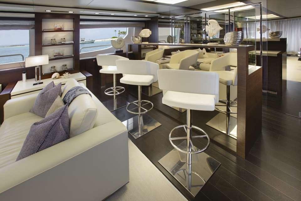a room with a bed and stools aboard INSIEME Yacht for Charter