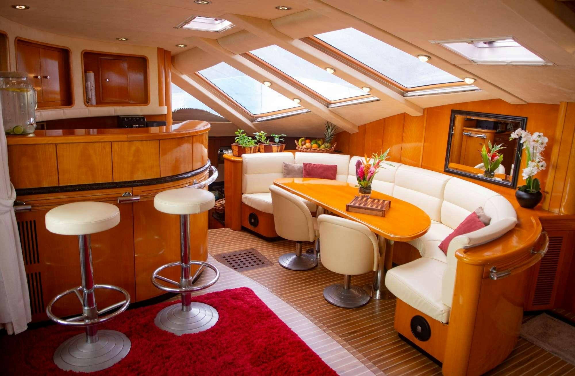 a room with a table chairs and a red rug aboard FELICIA Yacht for Charter