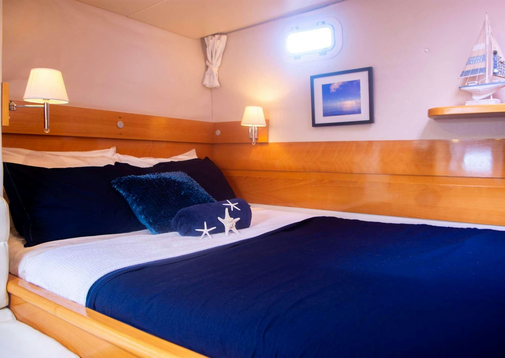 a bed with blue sheets aboard FELICIA Yacht for Charter