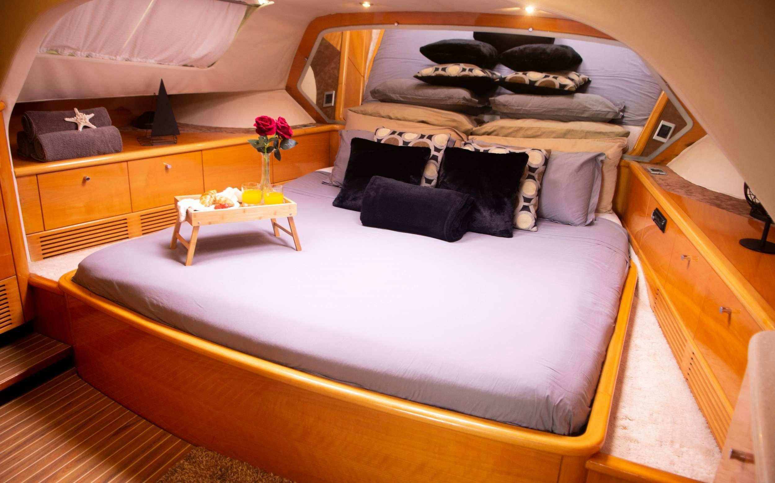 a bed with a white comforter aboard FELICIA Yacht for Charter