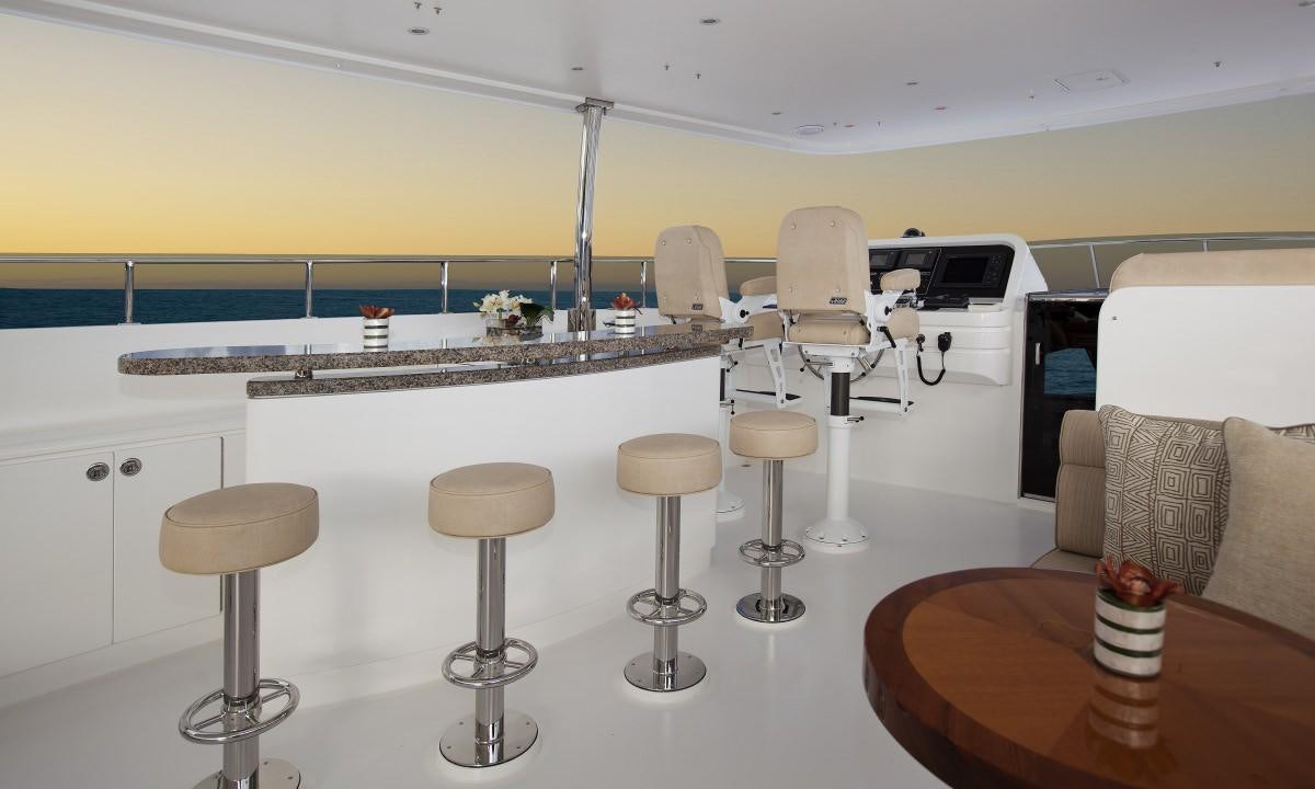 a room with stools and a table and chairs aboard CARBON COPY Yacht for Charter