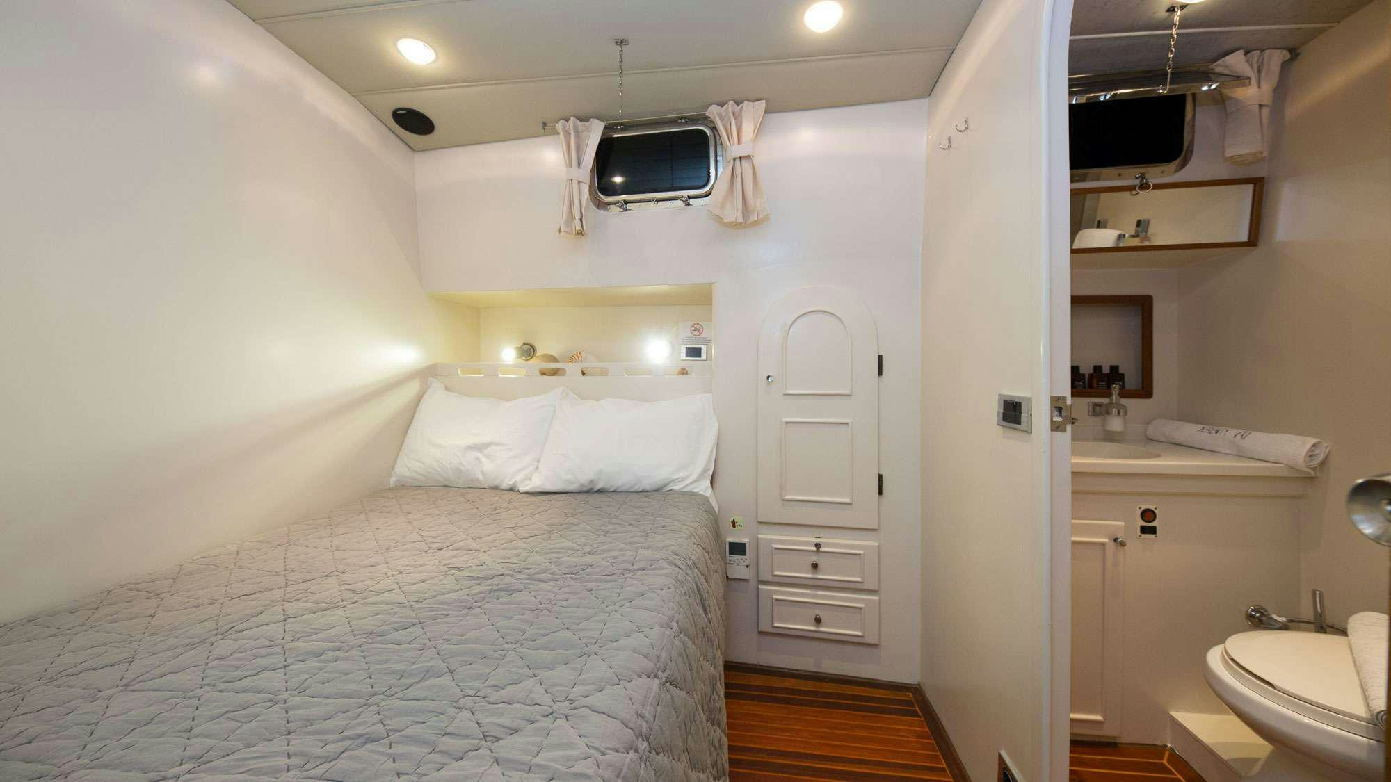 a bedroom with a bed and a television aboard SERENITY 70 Yacht for Charter