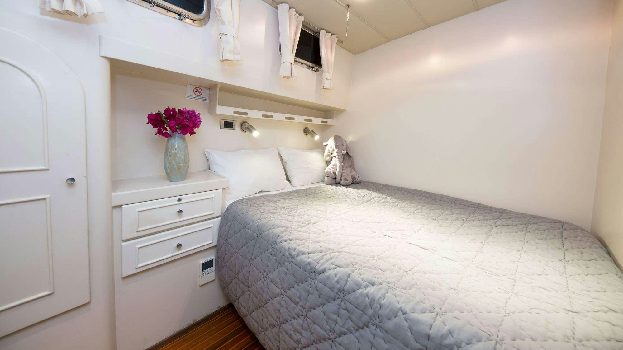 a bed with white sheets and pillows aboard SERENITY 70 Yacht for Charter
