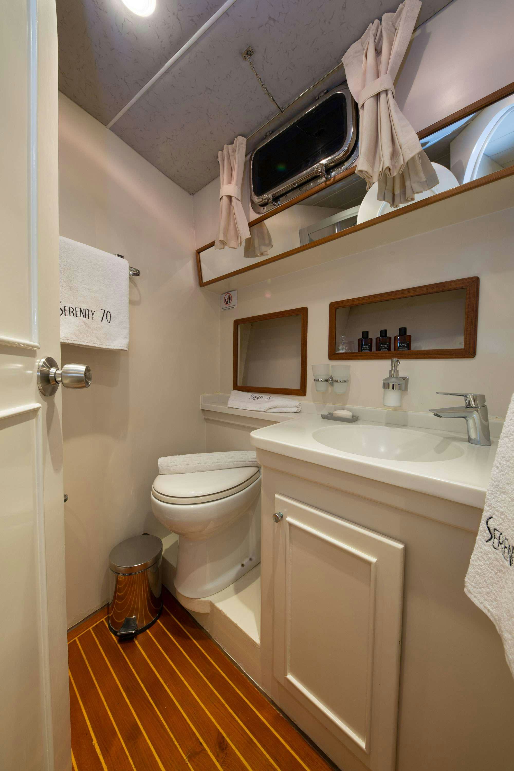 a bathroom with a toilet and sink aboard SERENITY 70 Yacht for Charter