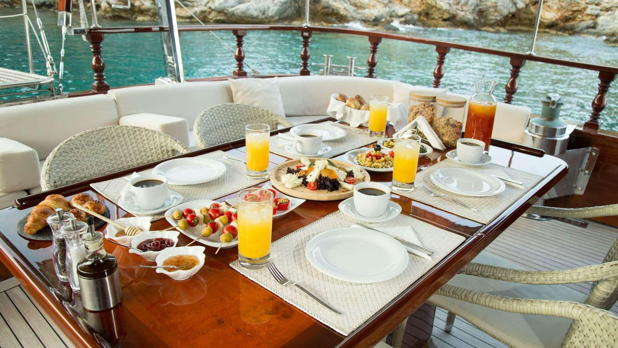 a table with food and drinks on it aboard SERENITY 70 Yacht for Charter