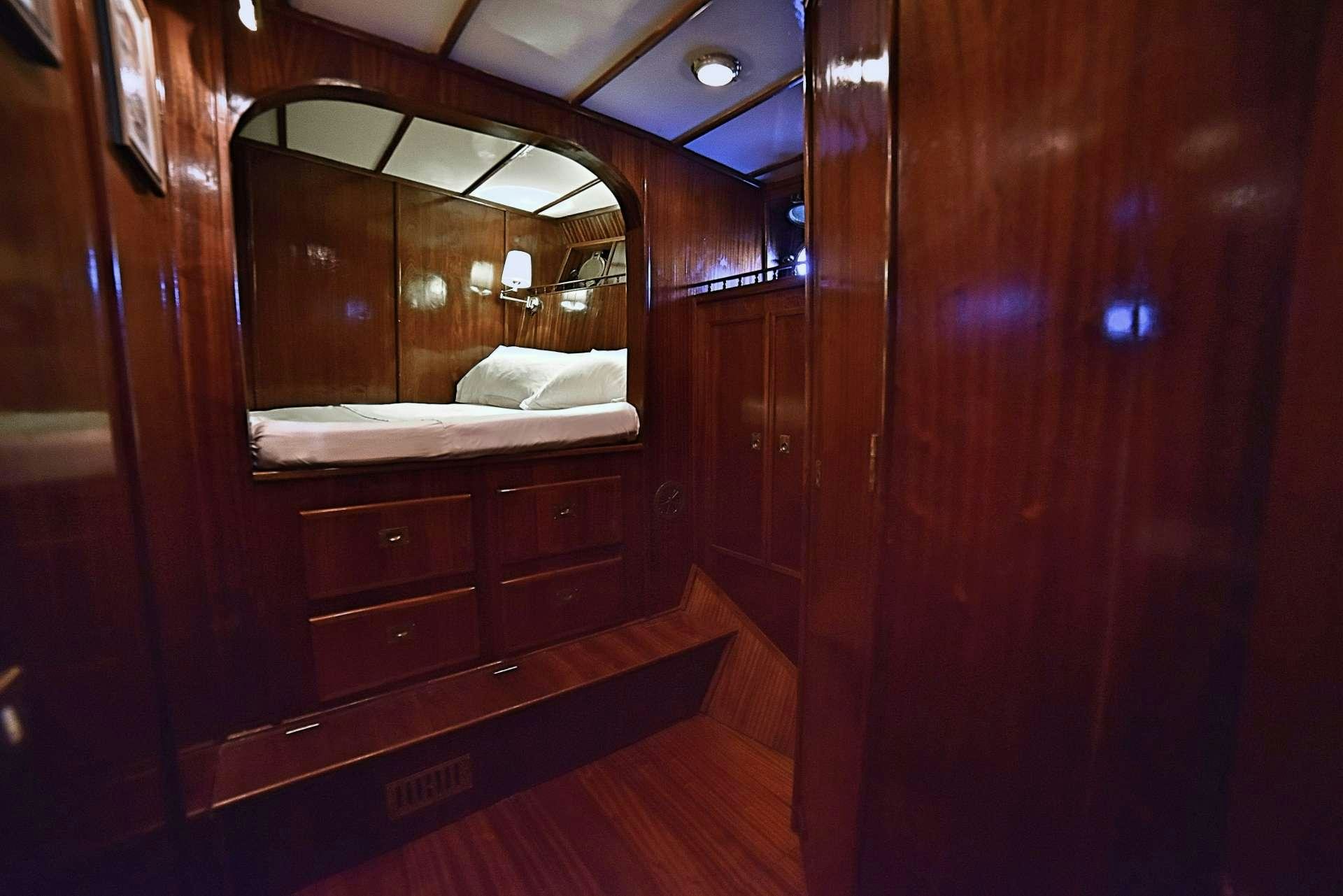 a room with a bed and a mirror aboard ENTRANCER Yacht for Charter