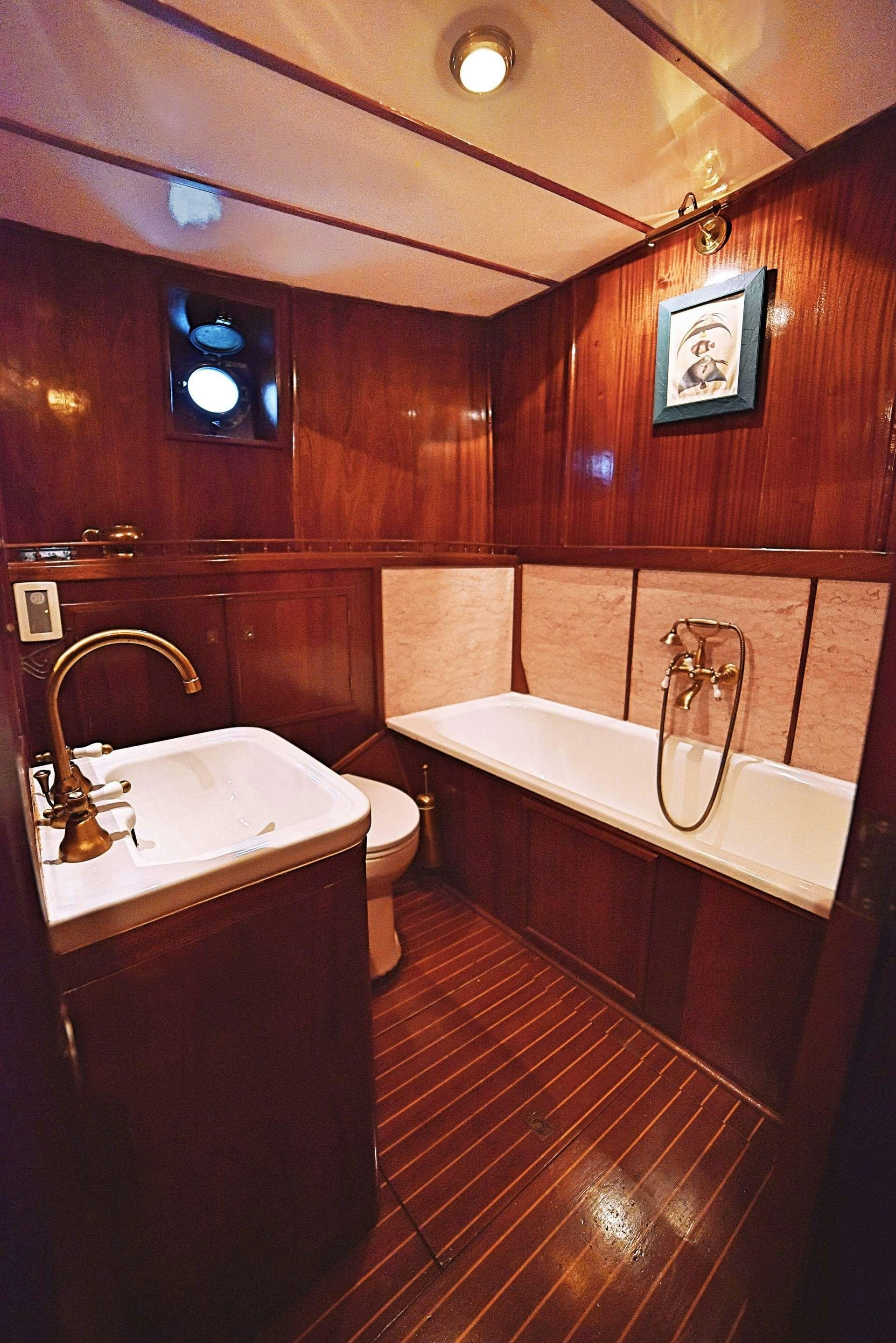 a bathroom with a tub sink and toilet aboard ENTRANCER Yacht for Charter