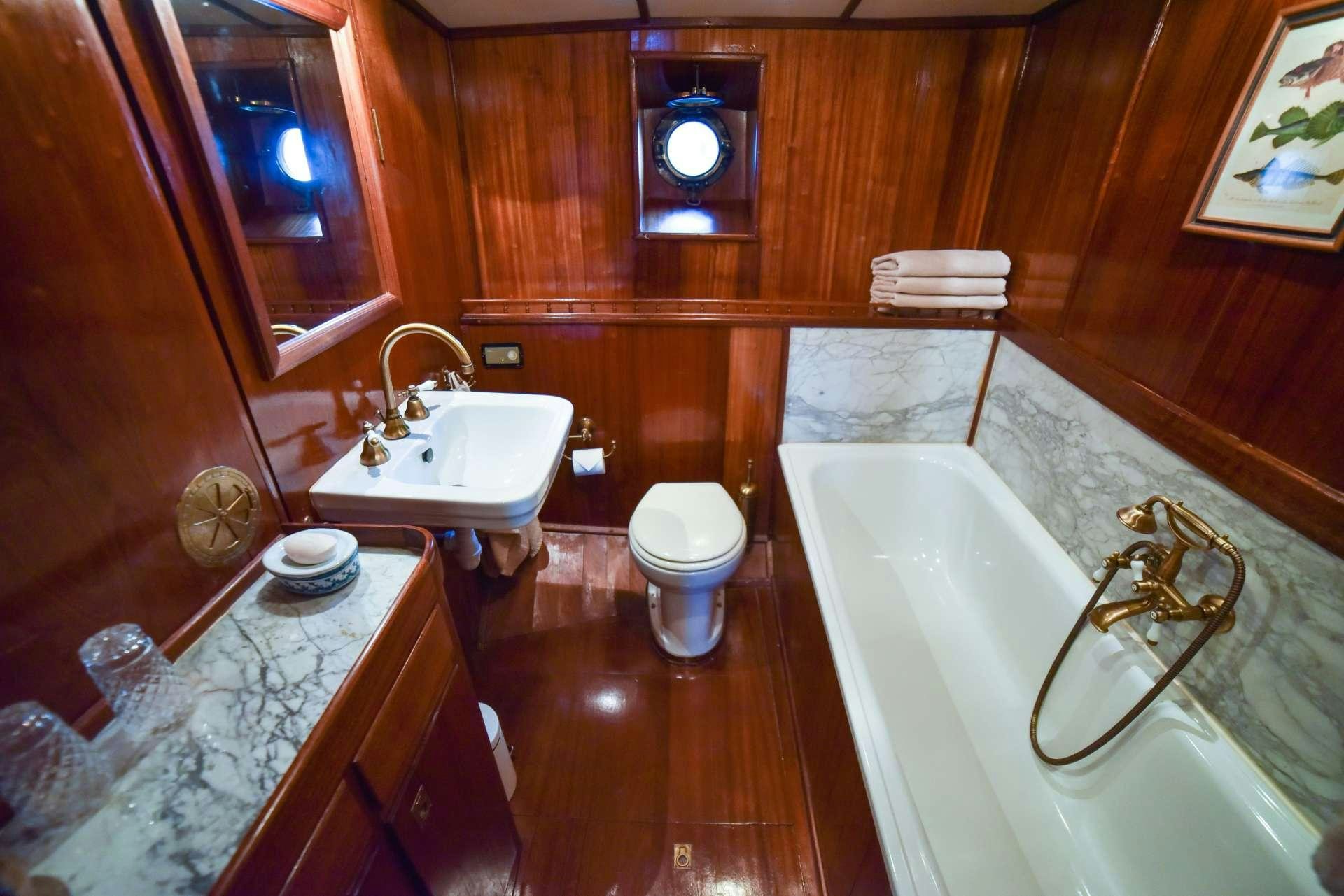 a bathroom with a tub sink and toilet aboard ENTRANCER Yacht for Charter