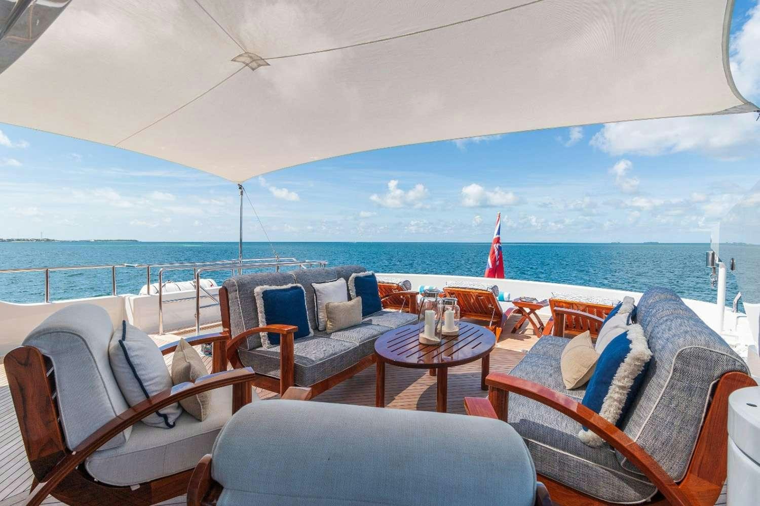 a room with a table chairs and a view of the ocean aboard GITANA Yacht for Charter