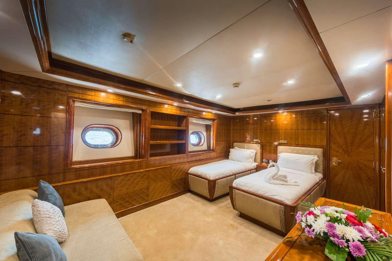 a room with a bed and a couch aboard ASHENA Yacht for Charter