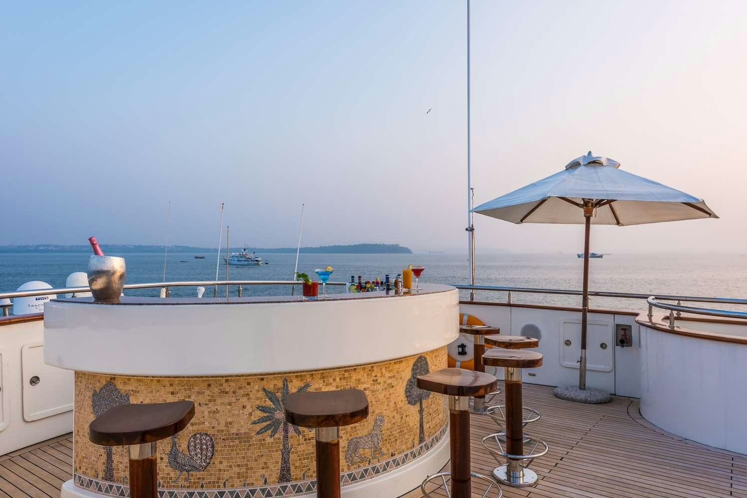 a room with a table and chairs and umbrellas aboard ASHENA Yacht for Charter