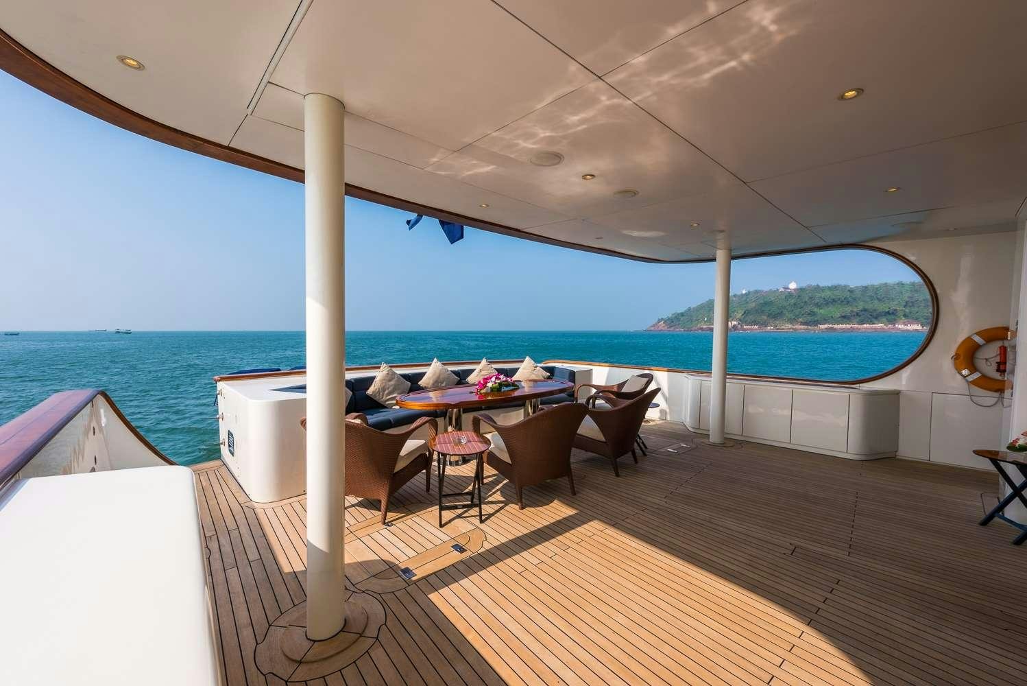 a room with a table and chairs and a large body of water aboard ASHENA Yacht for Charter