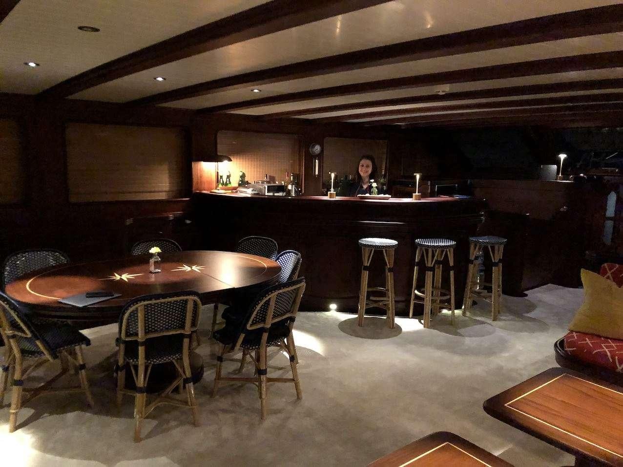 a large room with a table and chairs aboard VOYAGE Yacht for Charter