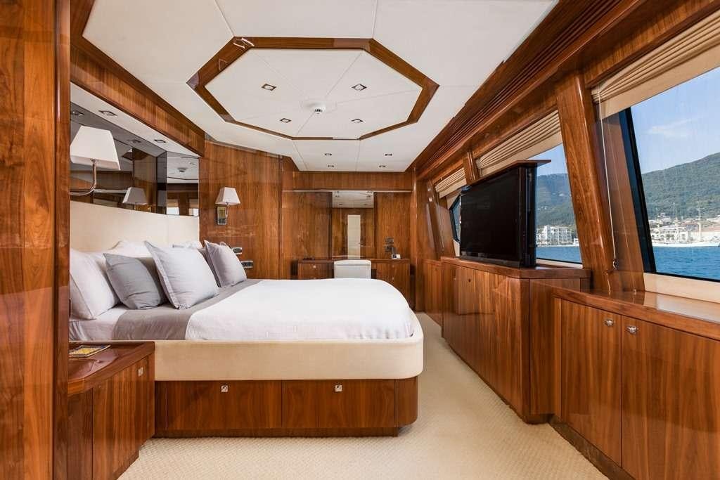 a room with a bed and a television aboard BARACUDA Yacht for Charter