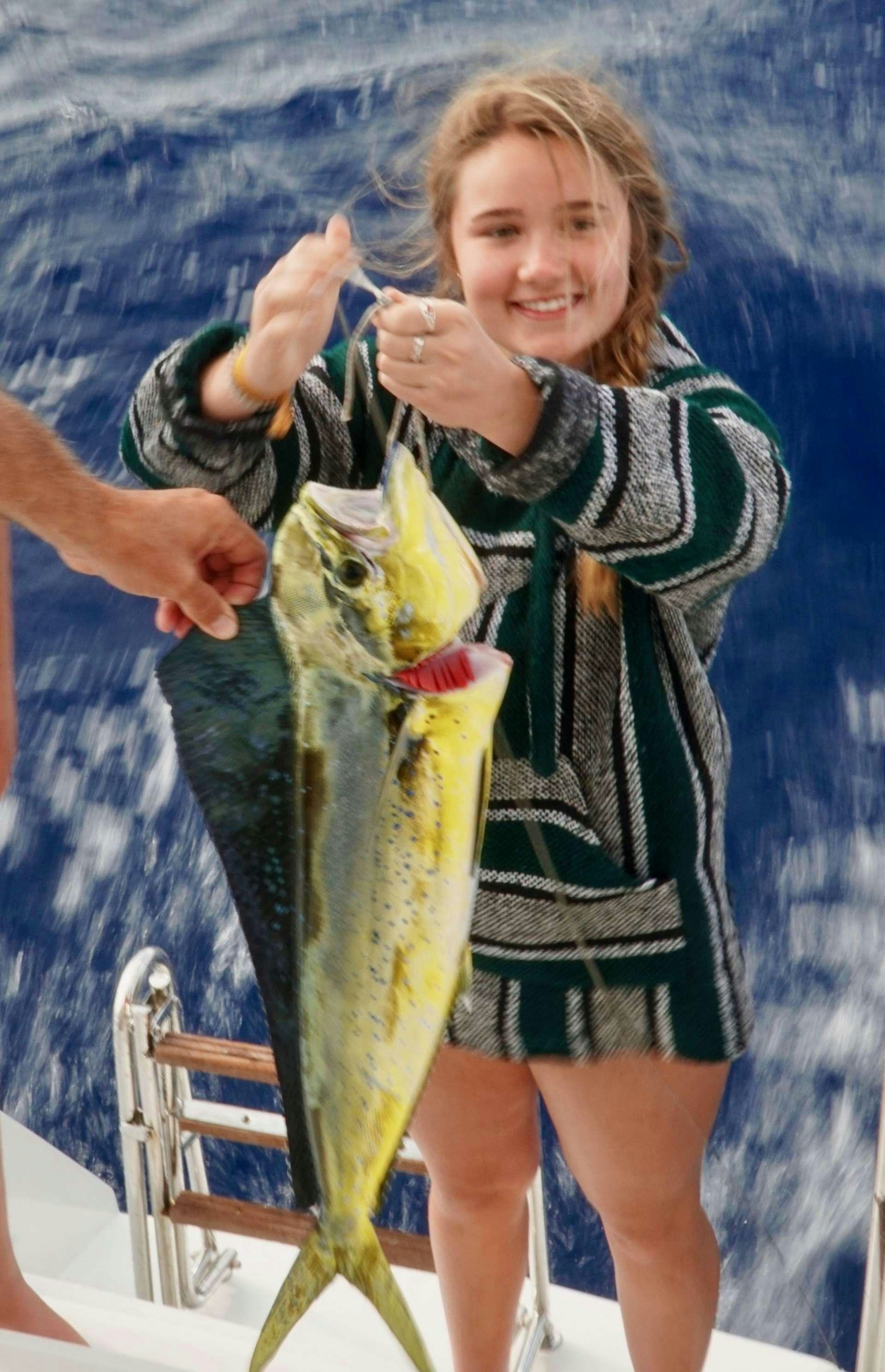 a girl holding a fish aboard SAMORU Yacht for Charter