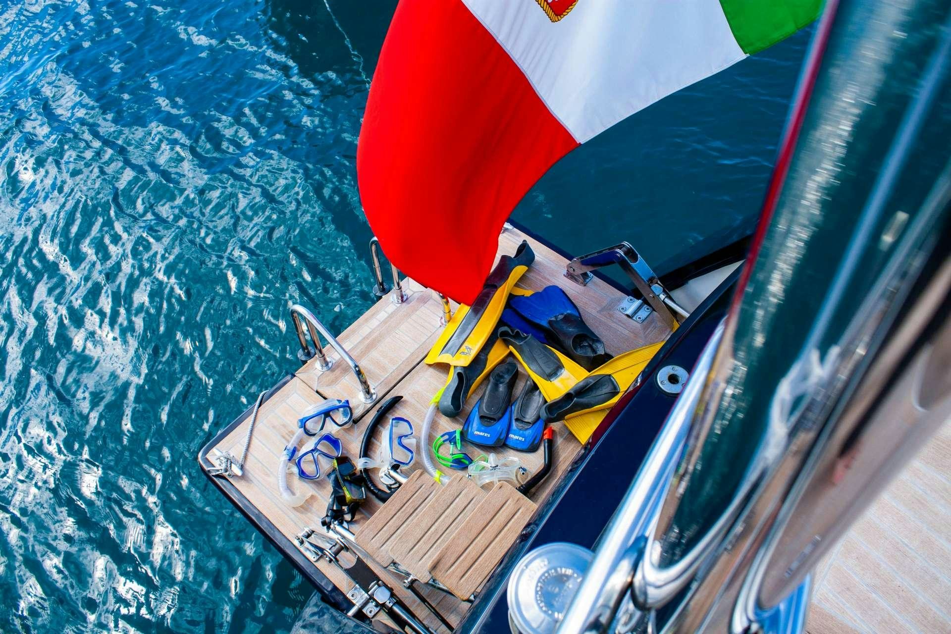 a boat with a flag on the front aboard CLASS IV Yacht for Charter