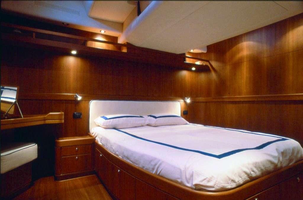 a bed with a wooden headboard aboard CLASS IV Yacht for Charter