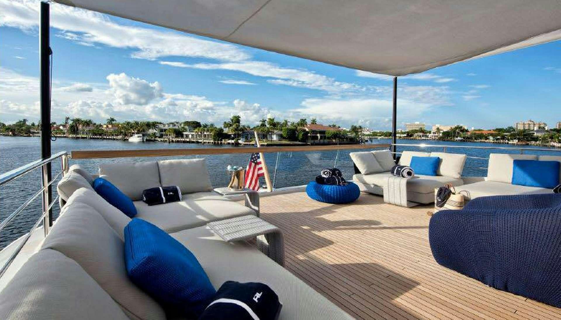 a large lounge area with a large blue and white lounge chair and a large blue and white striped aboard MORNING STAR Yacht for Charter