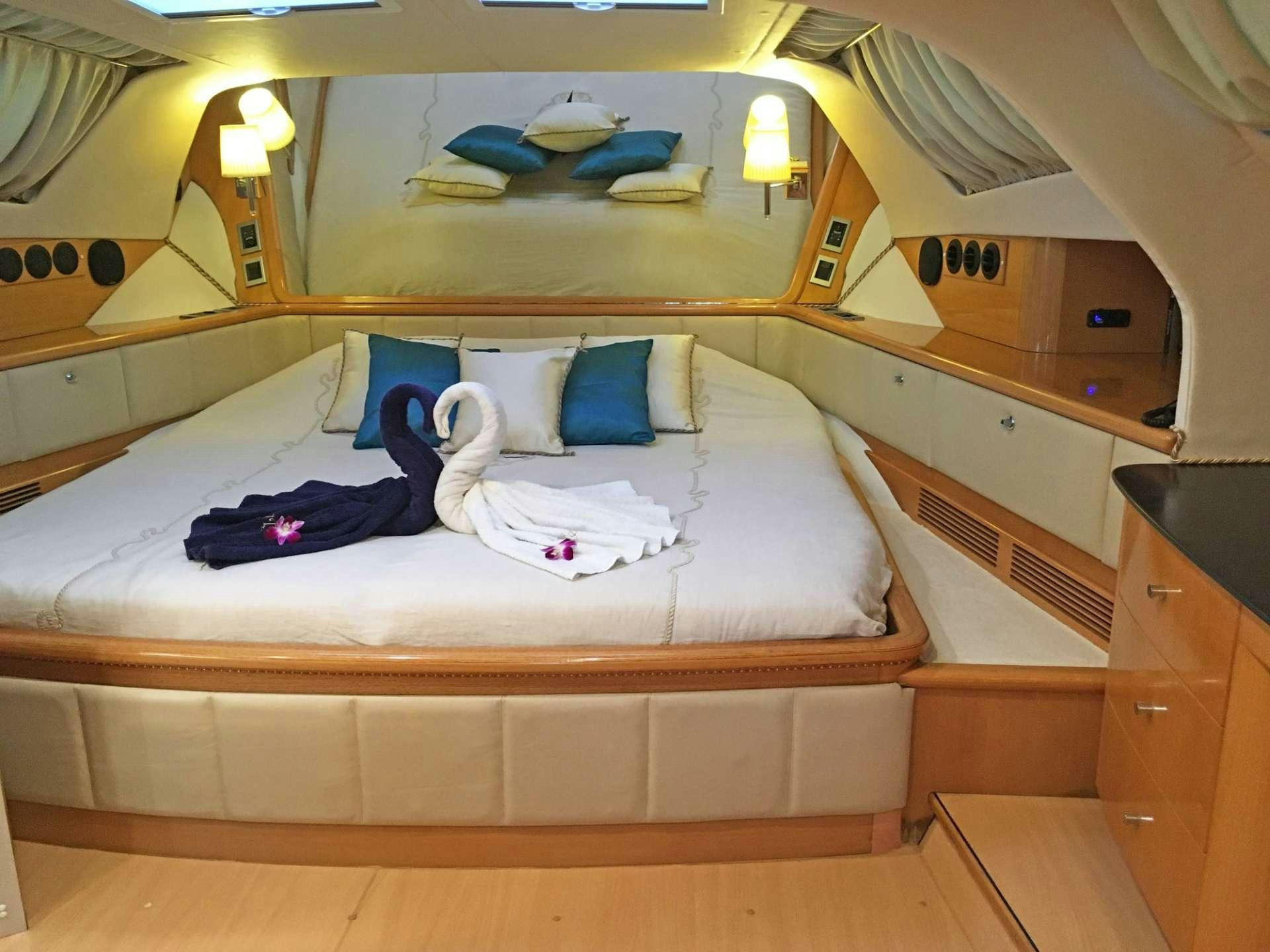 a bed with a white sheet and pillows on it aboard SAGITTARIUS Yacht for Charter
