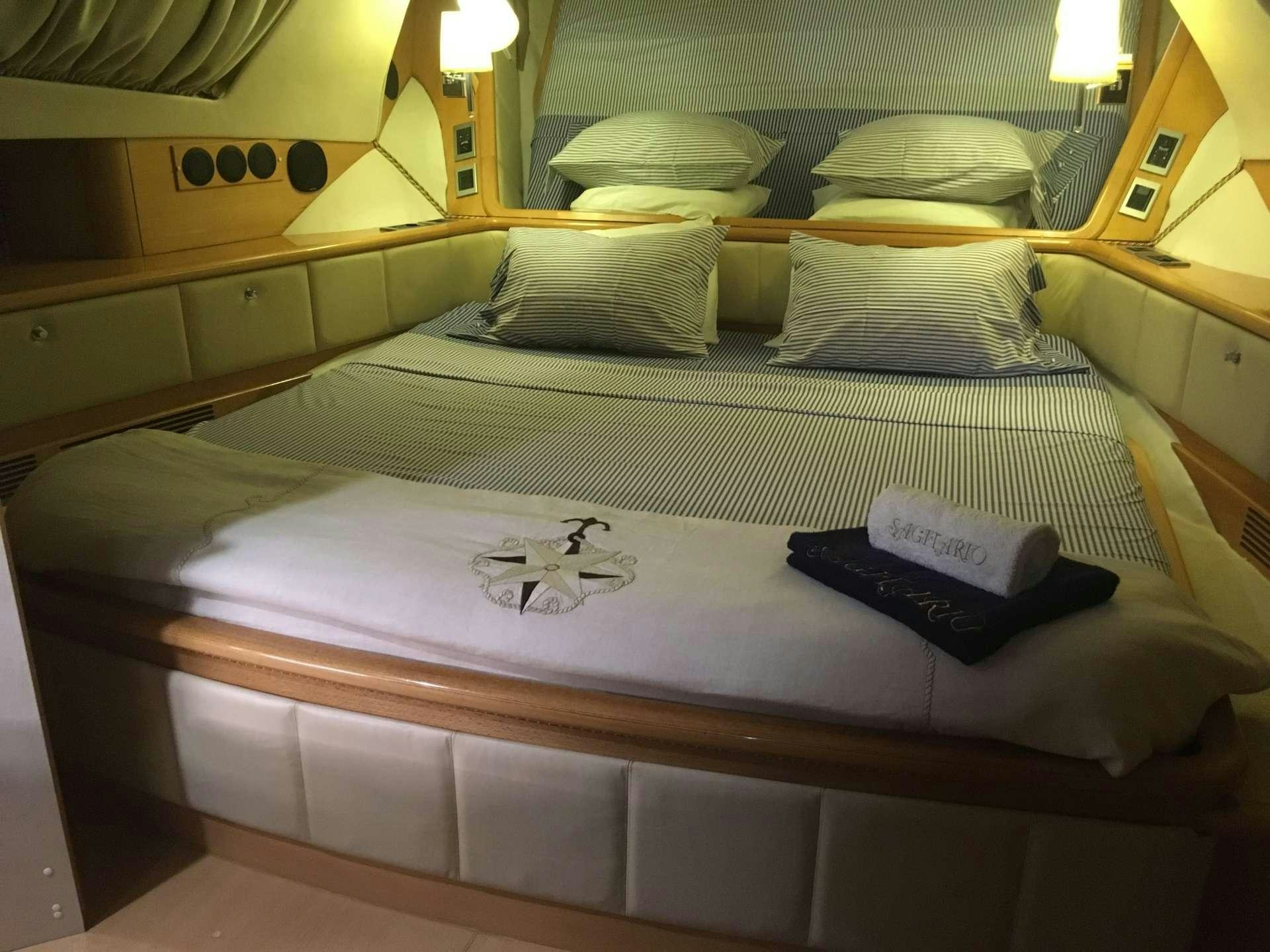 a bed with a white sheet and pillows on it aboard SAGITTARIUS Yacht for Charter