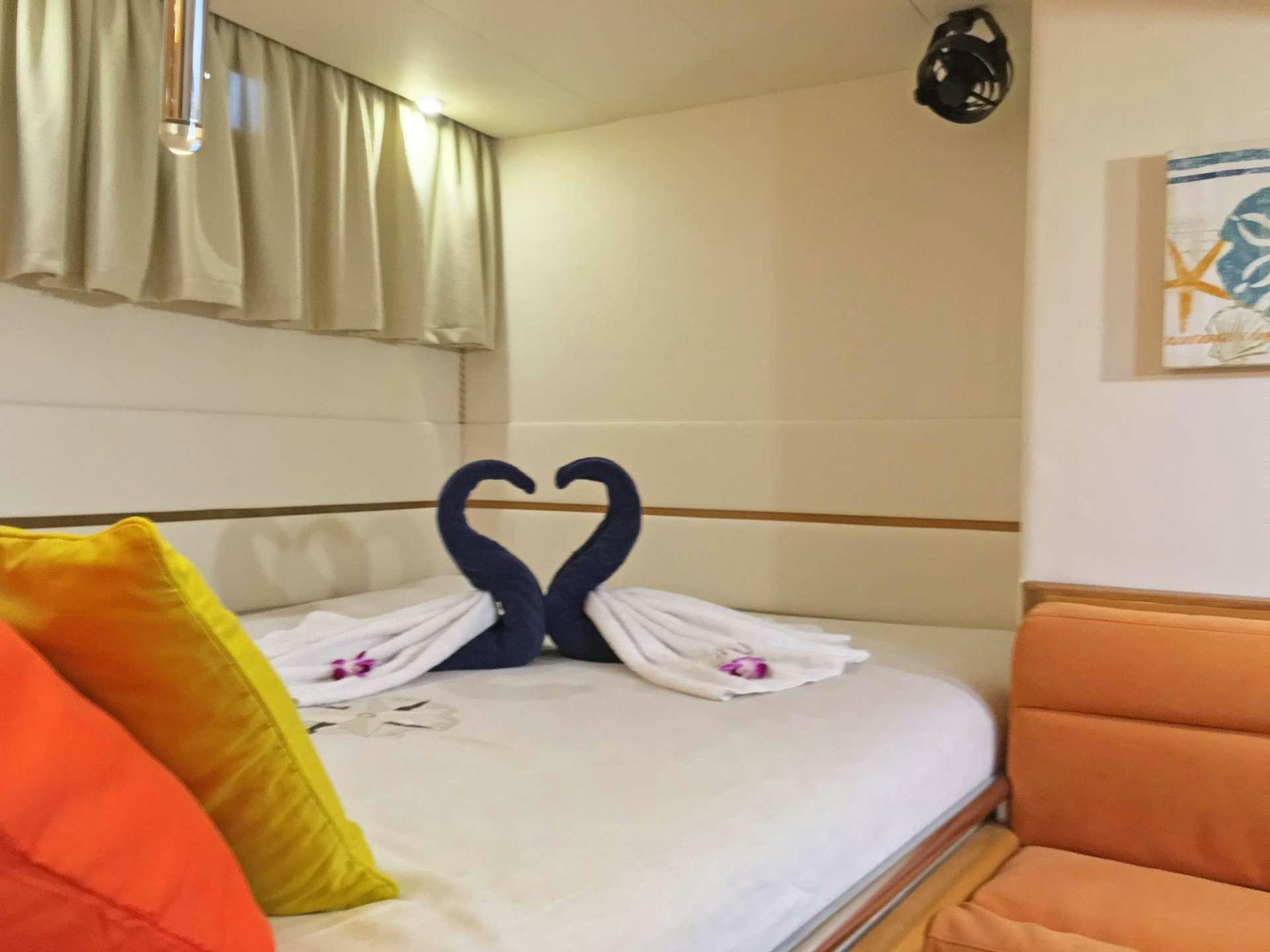 a bed with a blue pillow aboard SAGITTARIUS Yacht for Charter