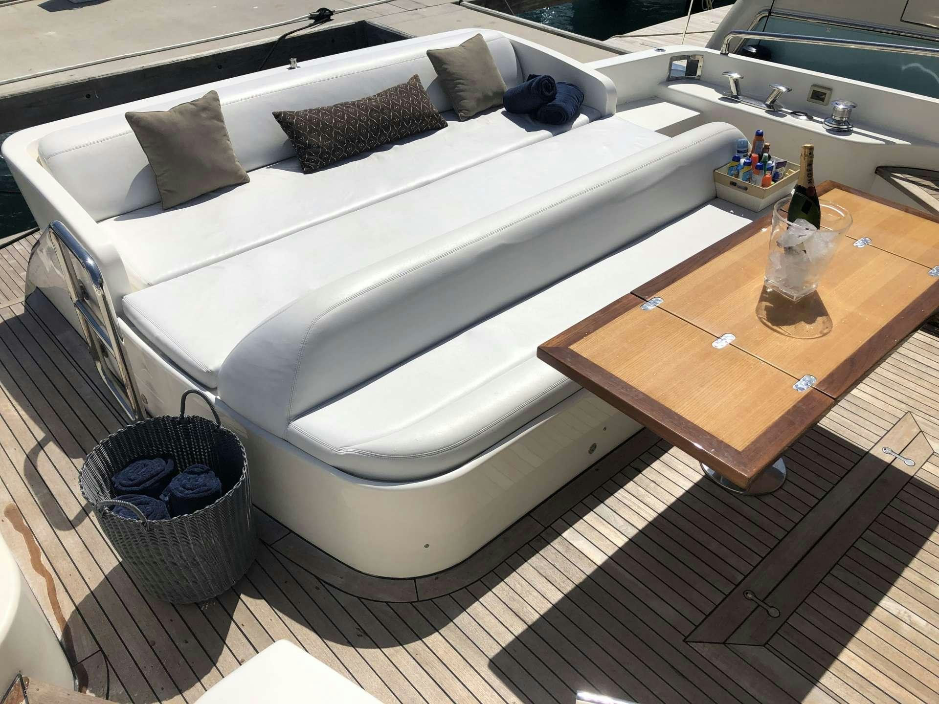 a white bathtub with a wooden table and a wooden bench aboard DOLCE VITA Yacht for Charter