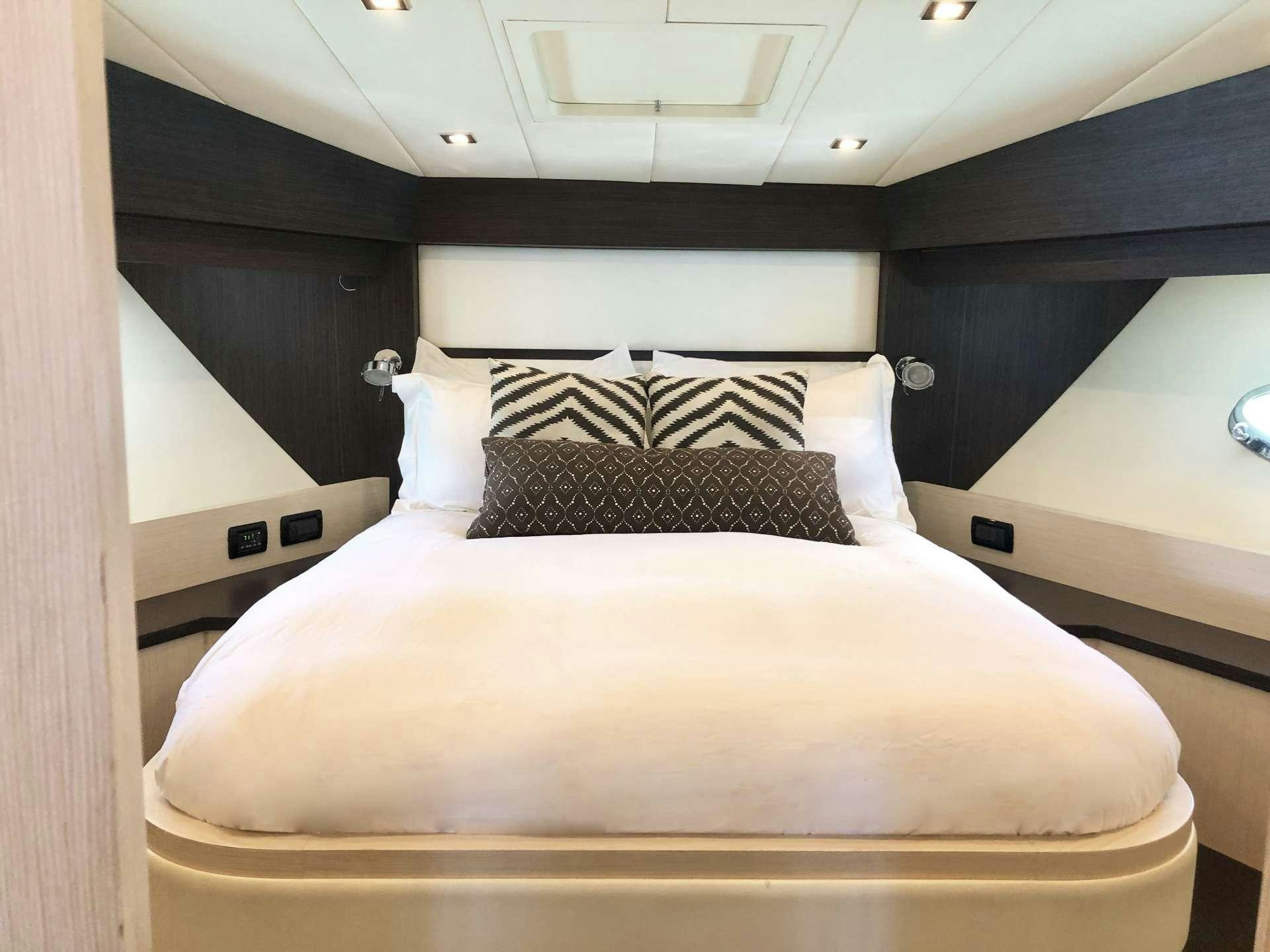 a bed with a black and white pillow on it aboard DOLCE VITA Yacht for Charter