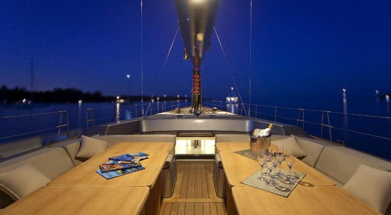 a deck with a view of a city at night aboard DARK SHADOW Yacht for Charter
