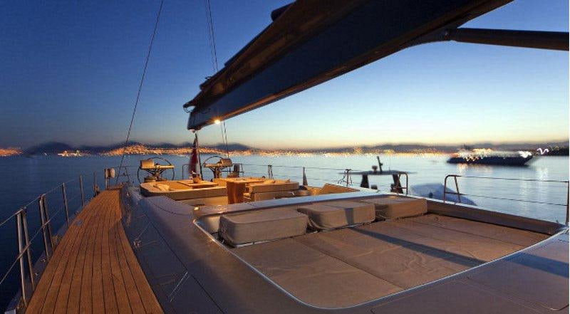 a deck with a view of the ocean and a boat on it aboard DARK SHADOW Yacht for Charter