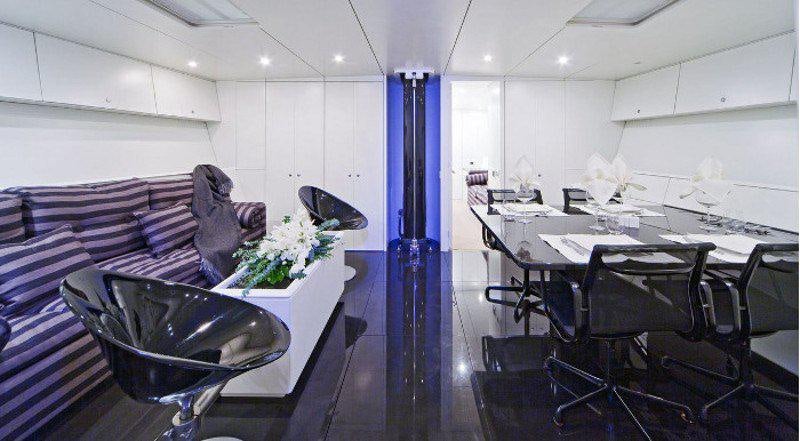 a room with a couch and a table and chairs aboard DARK SHADOW Yacht for Charter