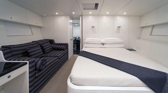 a room with a bed and a desk aboard DARK SHADOW Yacht for Charter