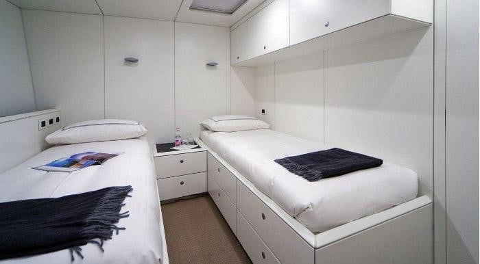 a room with a bed and a desk aboard DARK SHADOW Yacht for Charter