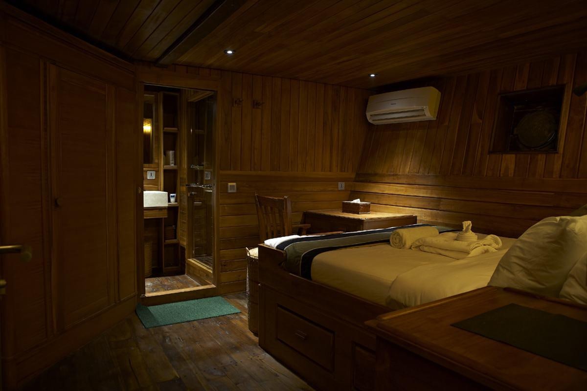 a room with a bed and a desk aboard DAMAI Yacht for Charter