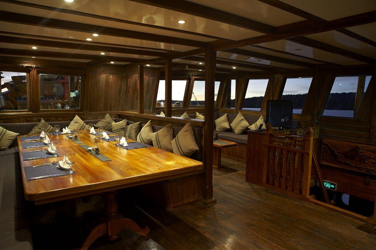 a living room with a wood table aboard DAMAI Yacht for Charter