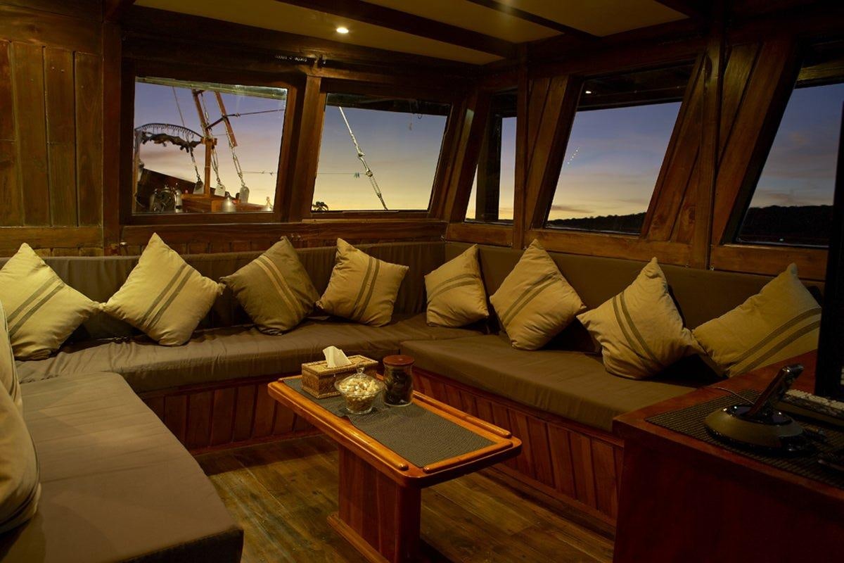 a room with a couch and a coffee table aboard DAMAI Yacht for Charter