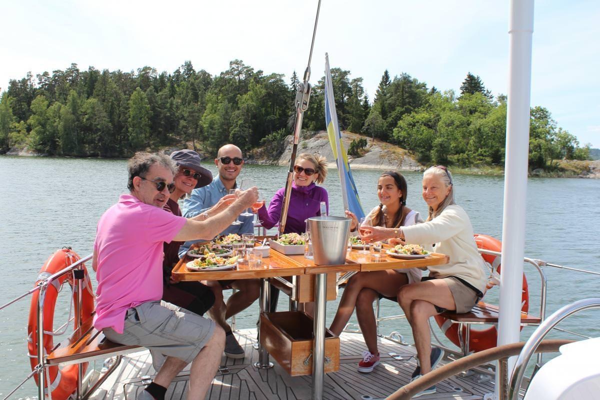 a group of people sitting at a table with food on it aboard ICHIBAN Yacht for Charter