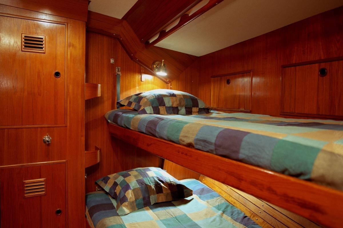 a bedroom with wooden walls aboard ICHIBAN Yacht for Charter