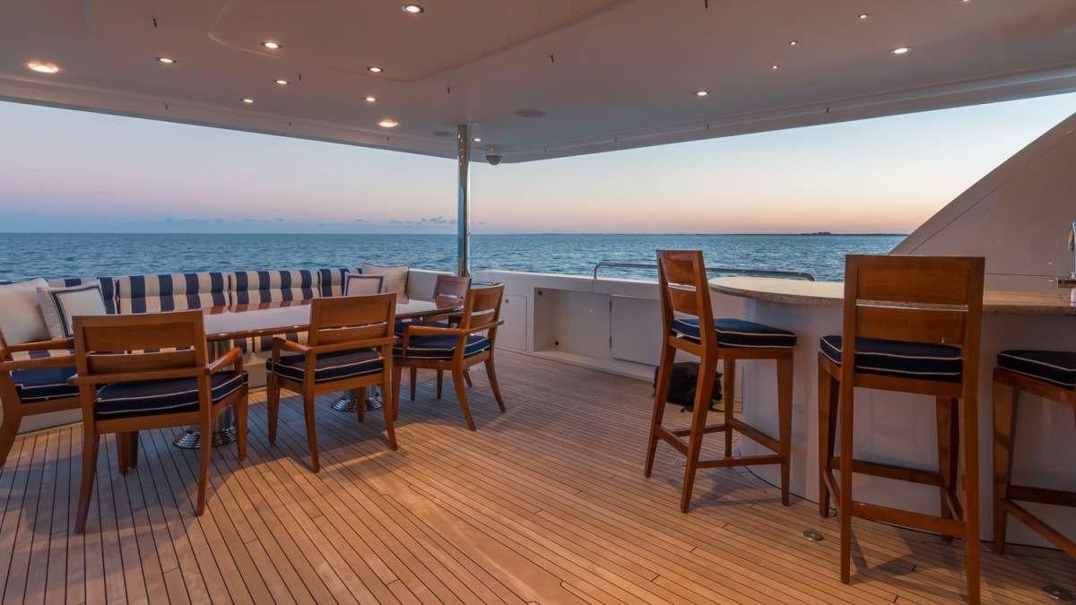 a deck with chairs and a pool aboard NAUTI N' Yacht for Charter