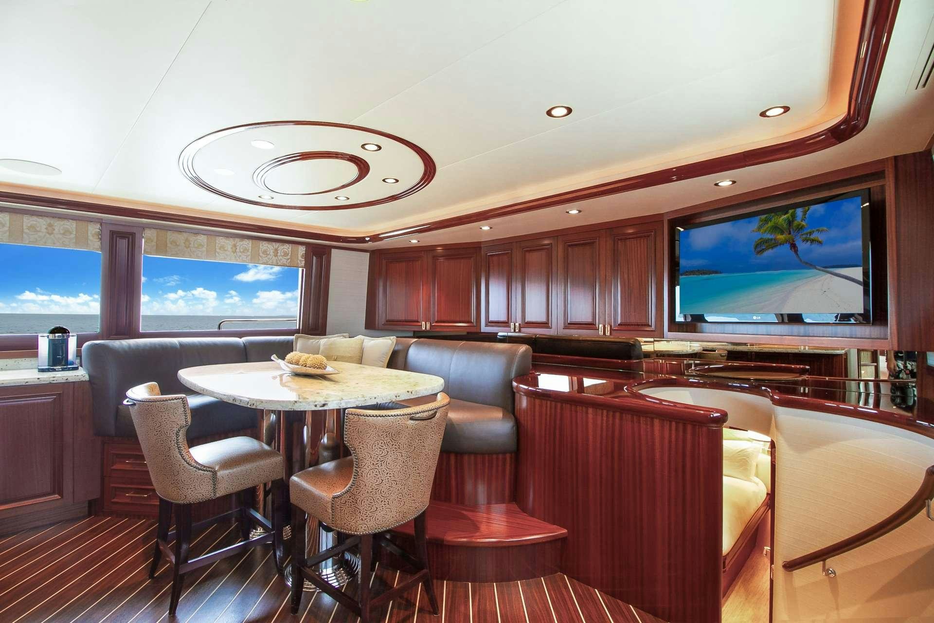 a room with a table and chairs aboard NAUTI N' Yacht for Charter