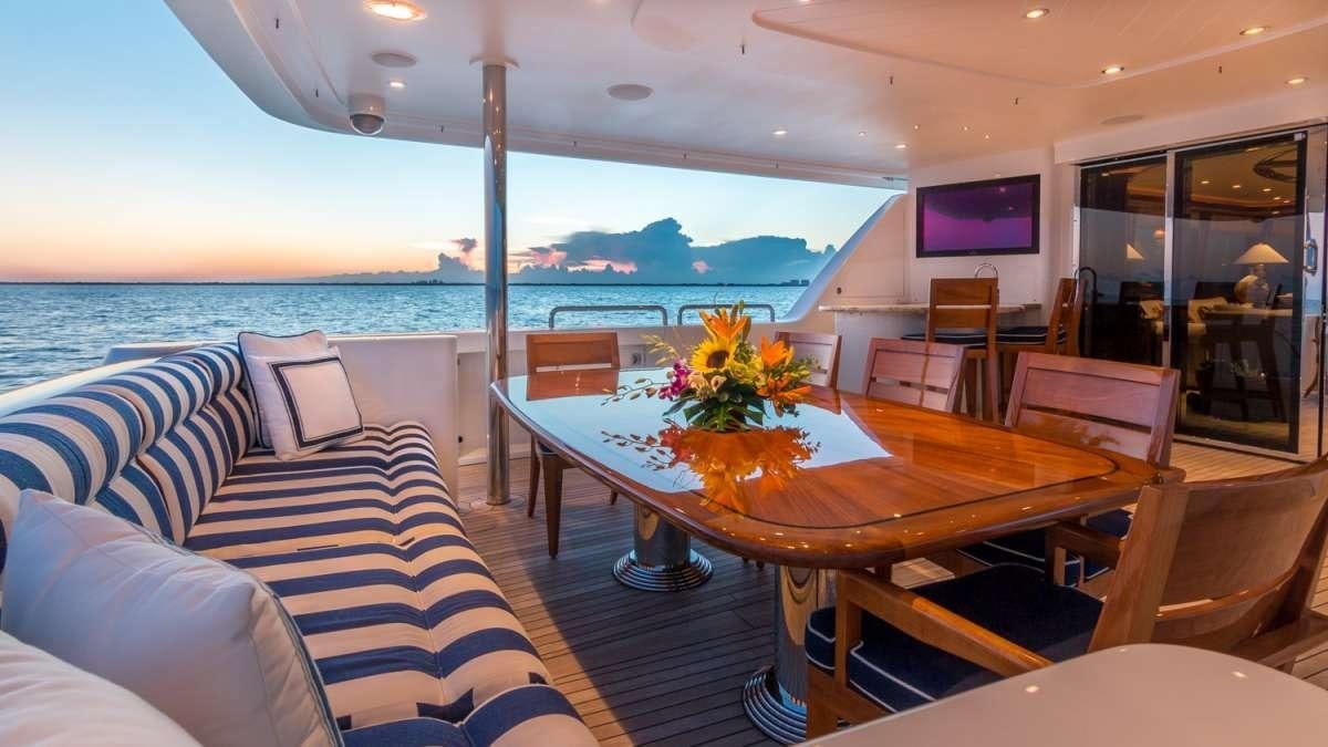 a room with tables and chairs aboard NAUTI N' Yacht for Charter