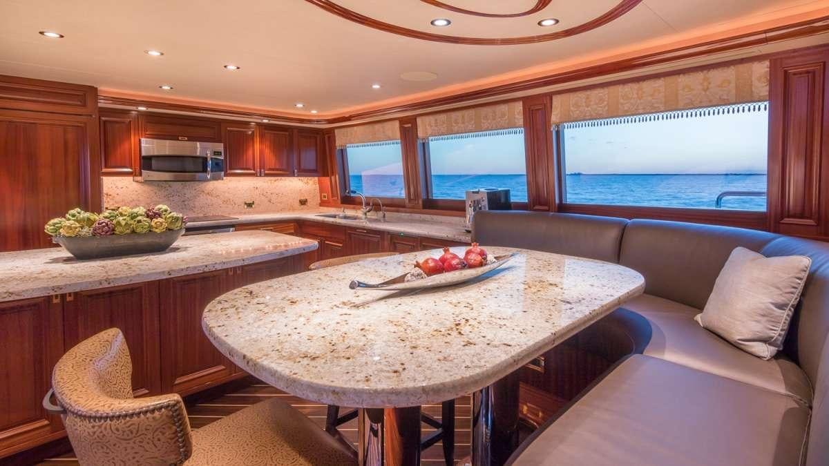 a kitchen with a table and chairs aboard NAUTI N' Yacht for Charter