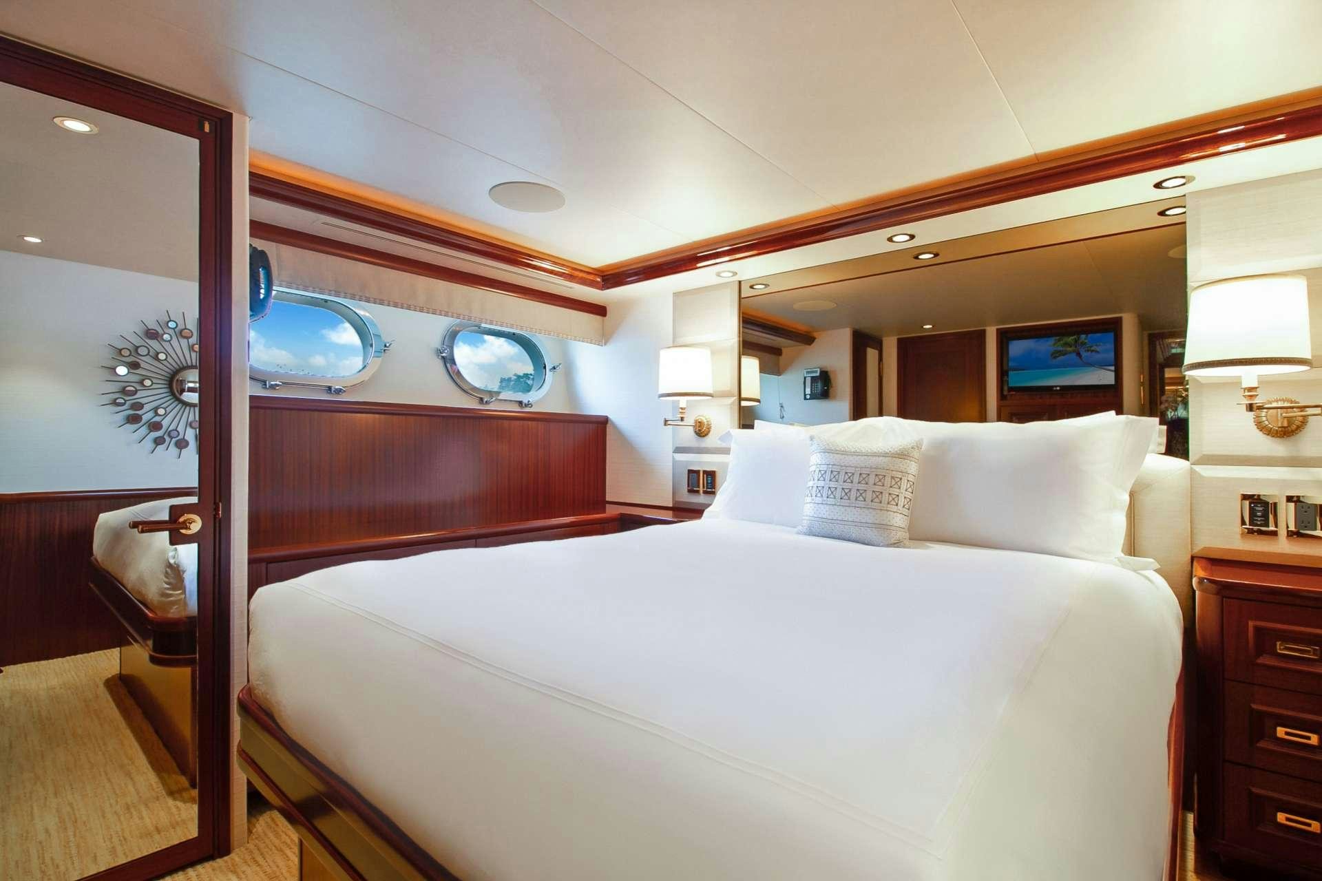 a bed with a large mirror above it aboard NAUTI N' Yacht for Charter
