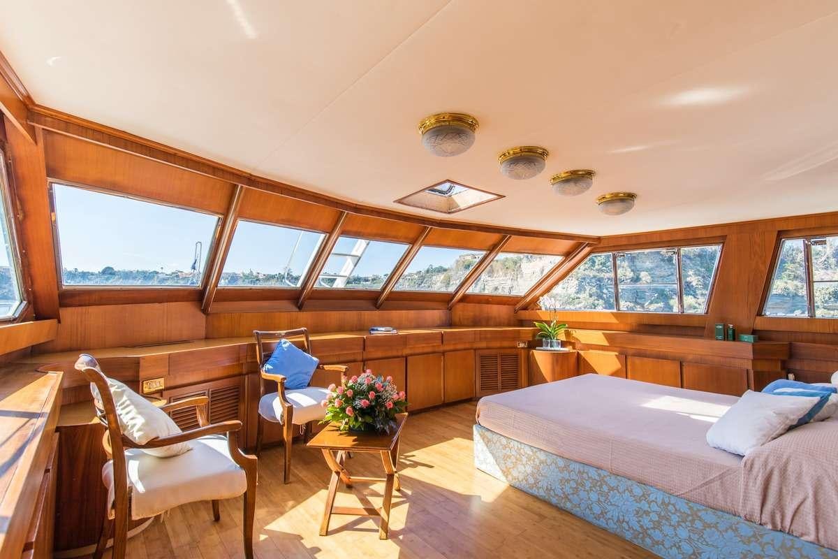 a room with a bed and a chair aboard Nafisa Yacht for Charter