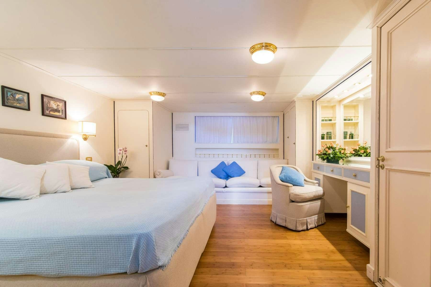a bedroom with a bed and a chair aboard Nafisa Yacht for Charter